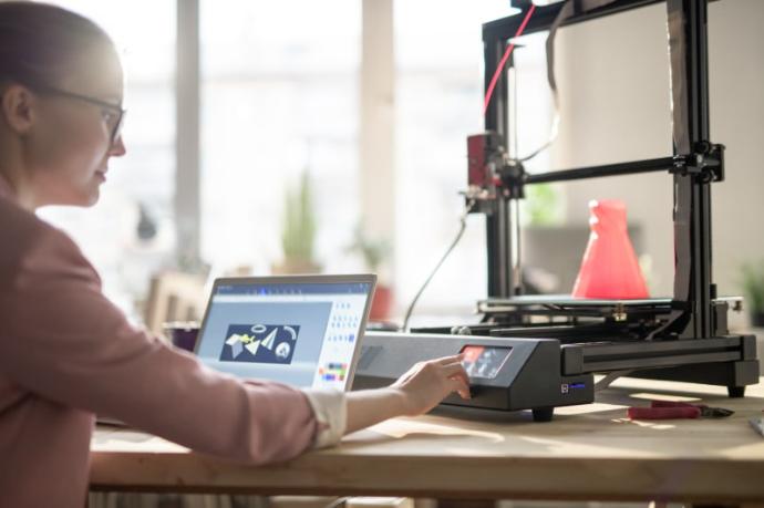 Mujer joven usando una impresora 3D