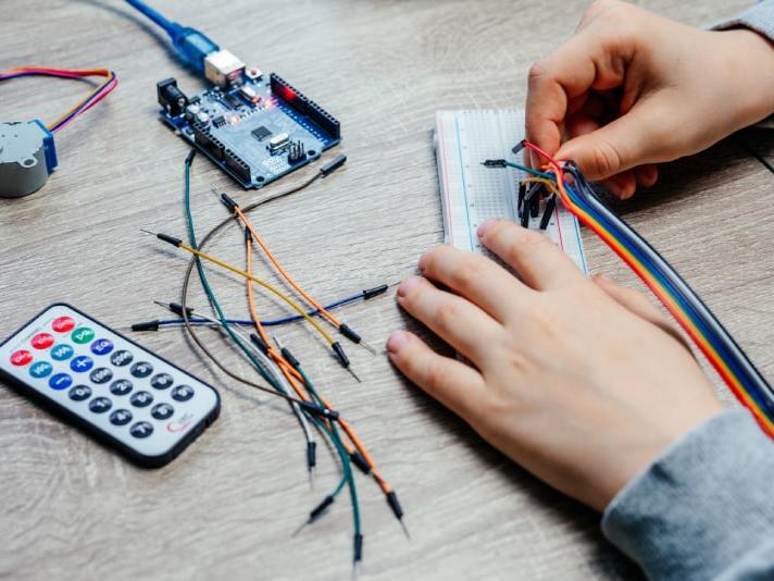 Manos conectando cables con Arduino