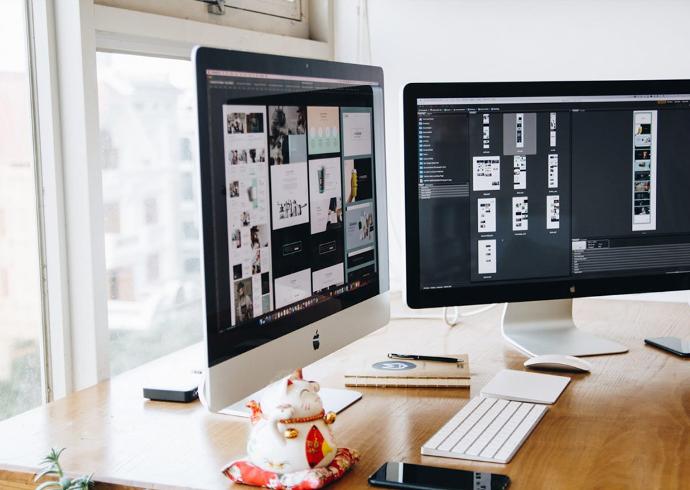 Pantallas de ordenador en escritorio con programa de diseño abierto