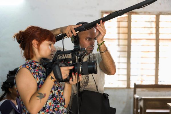 Dos personas grabando; una sujeta la cámara de vídeo y otro el micrófono